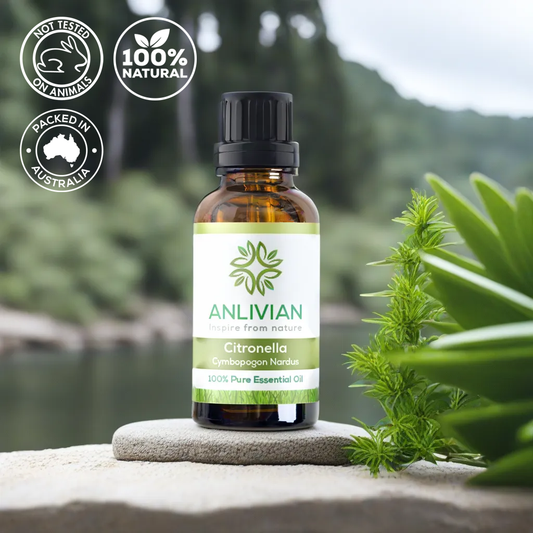 A bottle of Anlivian Citronella Essential Oil with a label showing the brand name and product type, set against a natural background with greenery and a body of water in the scenery.